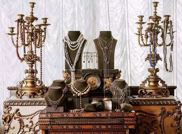 A close view of jewel-toned glass objects and gold jewelry inside the Jaffa maison